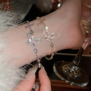 Close-up of pink zircon butterfly bracelet with micro-pave crystals on female wrist