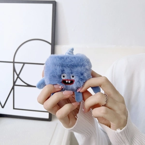 Close-up of blue plush monster case for AirPods held in hands with soft texture