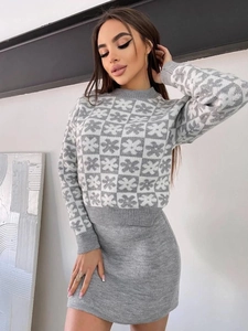 Detailed knit texture of grey and white checkerboard jacquard pattern on a cozy sweater