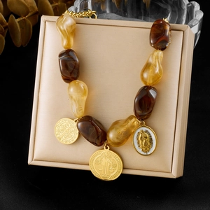 Maillard beaded necklace with irregular gold pendants displayed on a beige jewelry box
