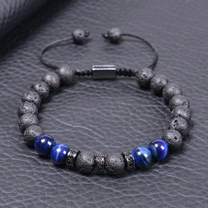 Detail of beaded men's bracelet with tiger eye, lava stone, and adjustable cord