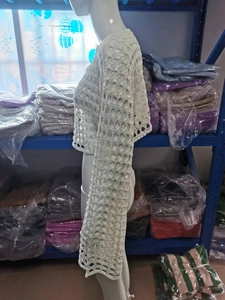 Detalle del tejido de punto de la blusa de ganchillo blanca con elegantes mangas acampanadas