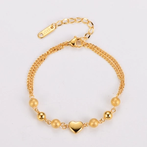 Close-up of golden 18KGP bead bracelet with heart pendant and lobster clasp detail