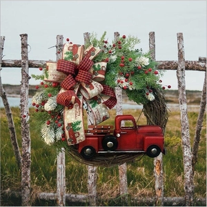 Outdoor view of a Christmas wreath with red truck and plaid Merry Christmas ribbon