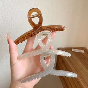 Three minimalist cross-style hair claws in brown, clear, and grey for women hair styling