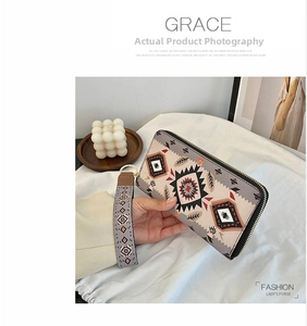 Detail of long ethnic geometric pattern wallet with gold hardware and wrist strap
