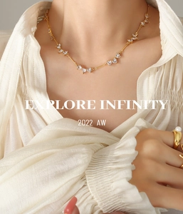 Close-up of elegant gold necklace featuring heart-shaped zircon stones on a model