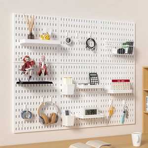 White modular pegboard wall organizer with shelves and hooks for home office storage