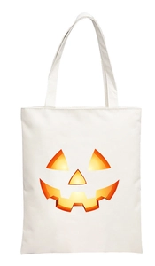 Detail of white canvas tote bag with vibrant orange glowing Halloween pumpkin face print