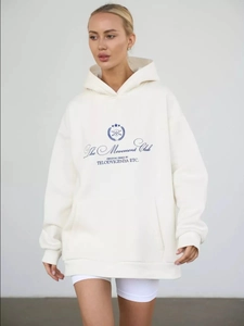 Detail of soft cream hoodie fabric with blue The Movement Club graphic and logo