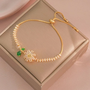 Golden sunflower bracelet with clear zircon and green leaves on jewelry box