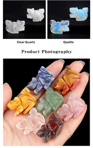 Handheld view of carved crystal animal figurines in various natural gemstones and opalite
