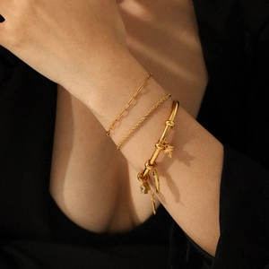 Ensemble de trois bracelets en acier inoxydable plaqué or 18k avec divers breloques