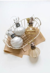 Detailed view of silver and champagne Christmas ornaments with animal figures in a basket