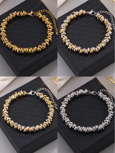 Macro detail of mixed color beaded bracelets in gold, silver and rose gold finishes