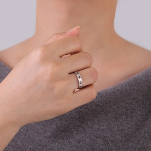Silver stainless steel open ring with hollow butterfly design worn by a female model