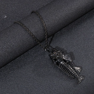 Macro detail of black metal fishbone pendant with intricate skeletal design on rope chain