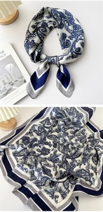 Detail of blue and white paisley silk scarf tied in a knot and displayed open on a desk