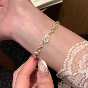 Détail macro du bracelet élégant plaqué or 18k avec perles et zircone au poignet