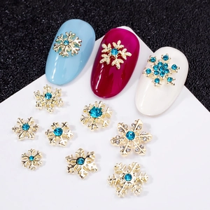 Bijoux d'ongles flocons dorés avec strass bleus sur faux ongles colorés
