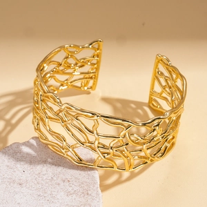Macro detail of 18K gold plated twisted mesh open bangle with artistic branch texture