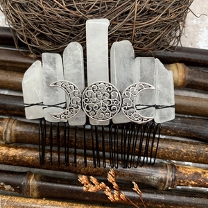 Macro detail of natural clear crystal hair comb with silver Triple Goddess moon symbol