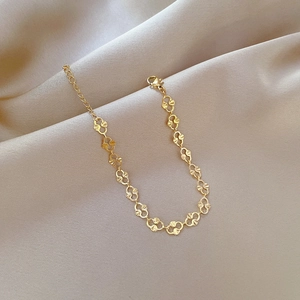 Close-up of golden titanium steel pig nose chain link bracelet on beige velvet background