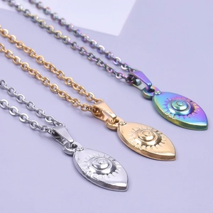 Detailansicht von drei augenförmigen Edelstahl-Anhängern in Silber, Gold und Regenbogen