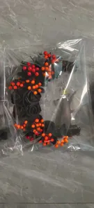 Detail of Halloween crescent wreath with black roses and orange berries in protective wrap