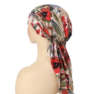 Detail of floral headscarf with red and green prints and long ties on a mannequin