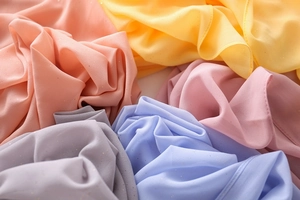 Gros plan détaillé du tissu mousseline coloré aux reflets dorés et texture soyeuse