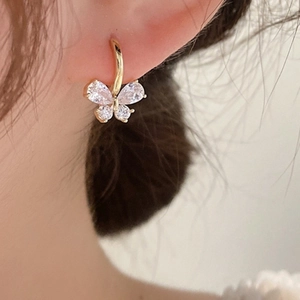 Elegant gold butterfly hoop earrings with sparkling zircon crystals worn by a model