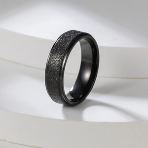 Detail of 2mm matte black stainless steel ring on white geometric background