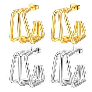 Détail de boucles d'oreilles géométriques en U multicouches en or et argent sur grille