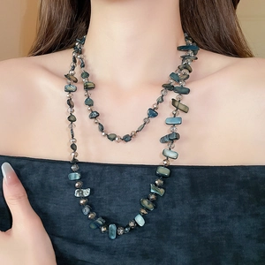 Detail of double-layered beaded necklace with dark irregular shells and grey crystals