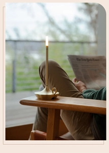 Modern brushed gold cordless lamp in warm outdoor setting for a cozy evening