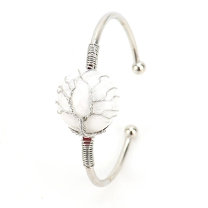 Macro shot of silver wire handmade tree of life wrap around a round white gemstone