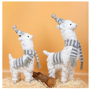 Detail van twee witte alpaca knuffels met zilveren stippen en gebreide sjaals