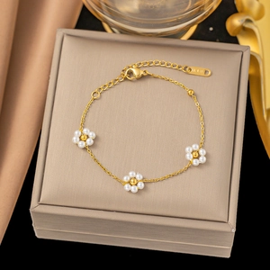 Elegant 18K gold chain bracelet featuring three delicate white pearl flower accents