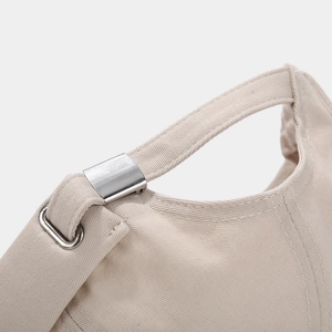 Detail of adjustable metal buckle and beige cotton fabric on the back of the beanie cap
