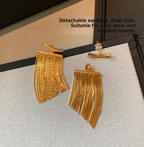 Close-up of detachable gold tassel earrings showing dual-wear style on display board
