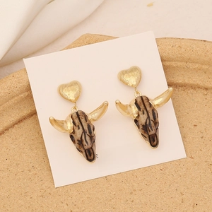 Close-up of vintage bull head earrings with golden heart studs and s925 silver needles