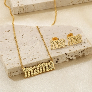 Goldenes Titanstahl Mama Schmuckset mit glitzernden Strasssteinen auf Steinplatte