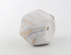 Detail view of geometric marble ceramic succulent pot with gold veins and drainage hole