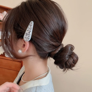 Sparkling zircon square arrow hair clip worn on brunette hair with elegant jewelry