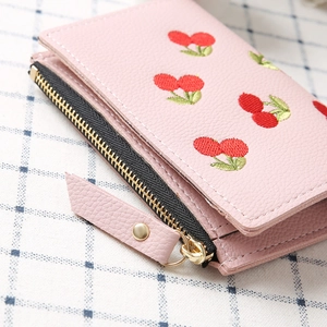 Close-up of pink faux leather short wallet featuring detailed red cherry embroidery
