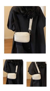 White crossbody bag with geometric woven strap and gold hardware detail