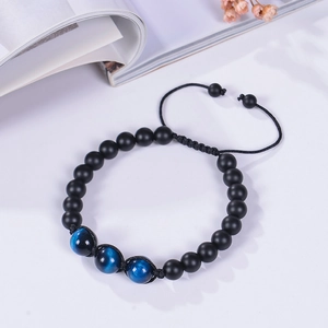 Detail of adjustable braided bracelet with 12mm matte black beads and blue tiger eye stones