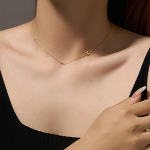 Elegant gold-plated M letter pendant necklace worn by a model on collarbone