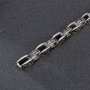 Detail of vintage silver stainless steel chain with embossed cross and sword patterns